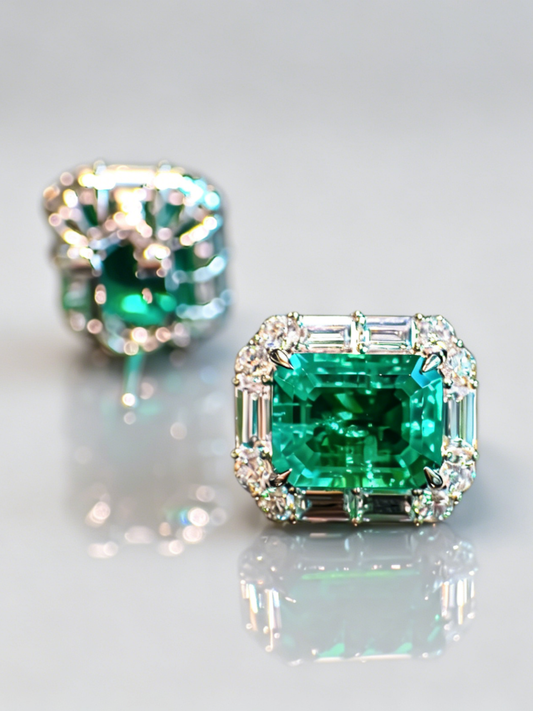 Emerald stud earrings with square emerald centers and diamond halo settings, small prongs
