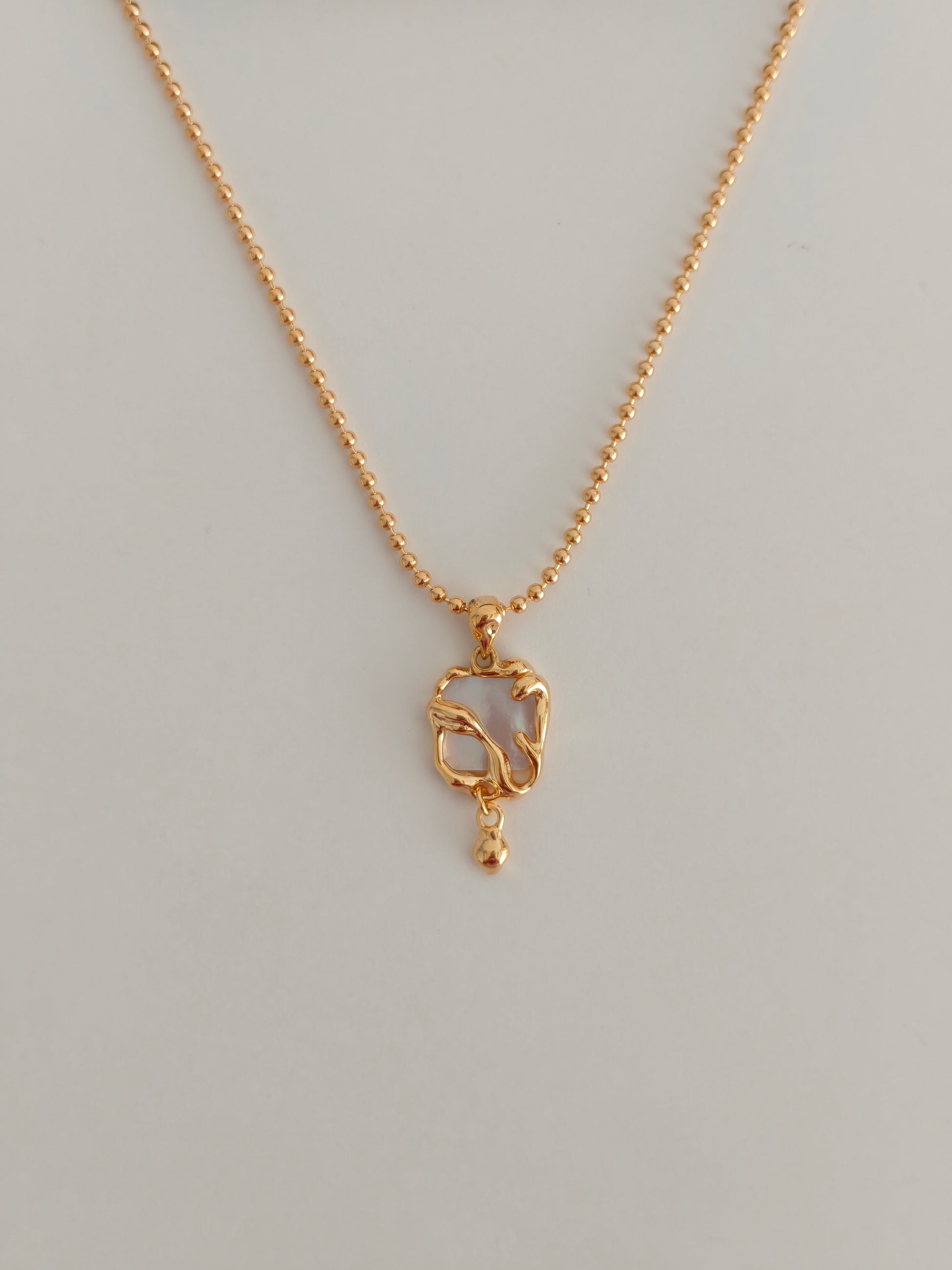 Gold-tone necklace with mother-of-pearl heart charm on fine chain