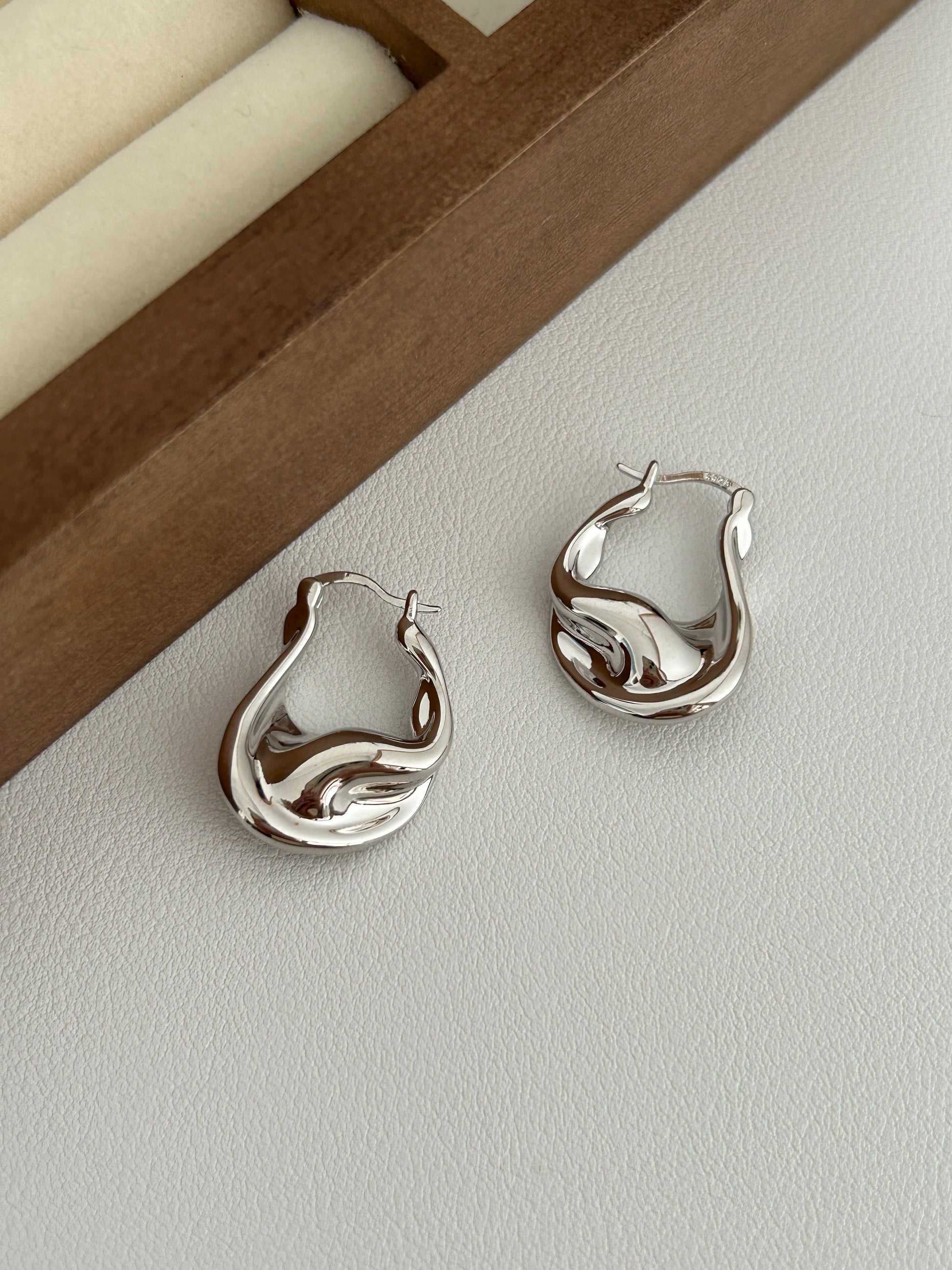 Sterling silver fluid hoop earrings, wavy sculpted profile