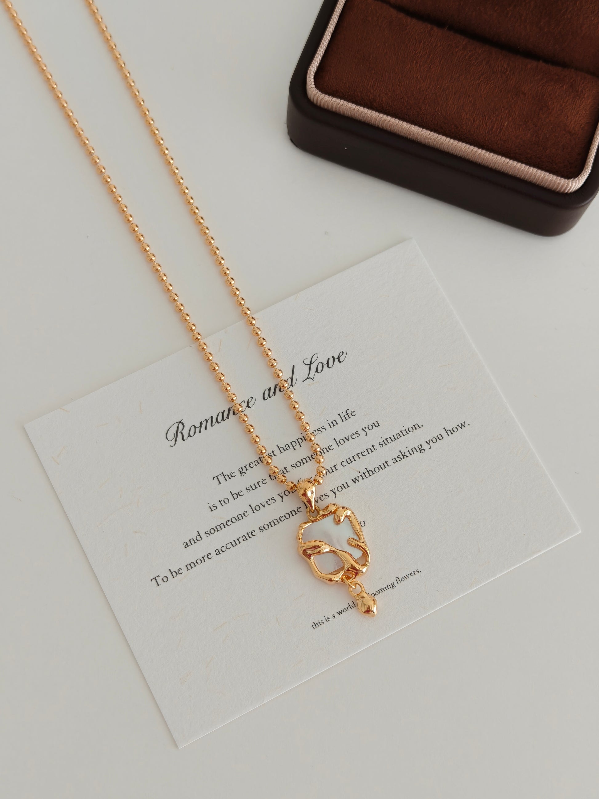 Gold-tone necklace with mother-of-pearl heart charm, close-up view