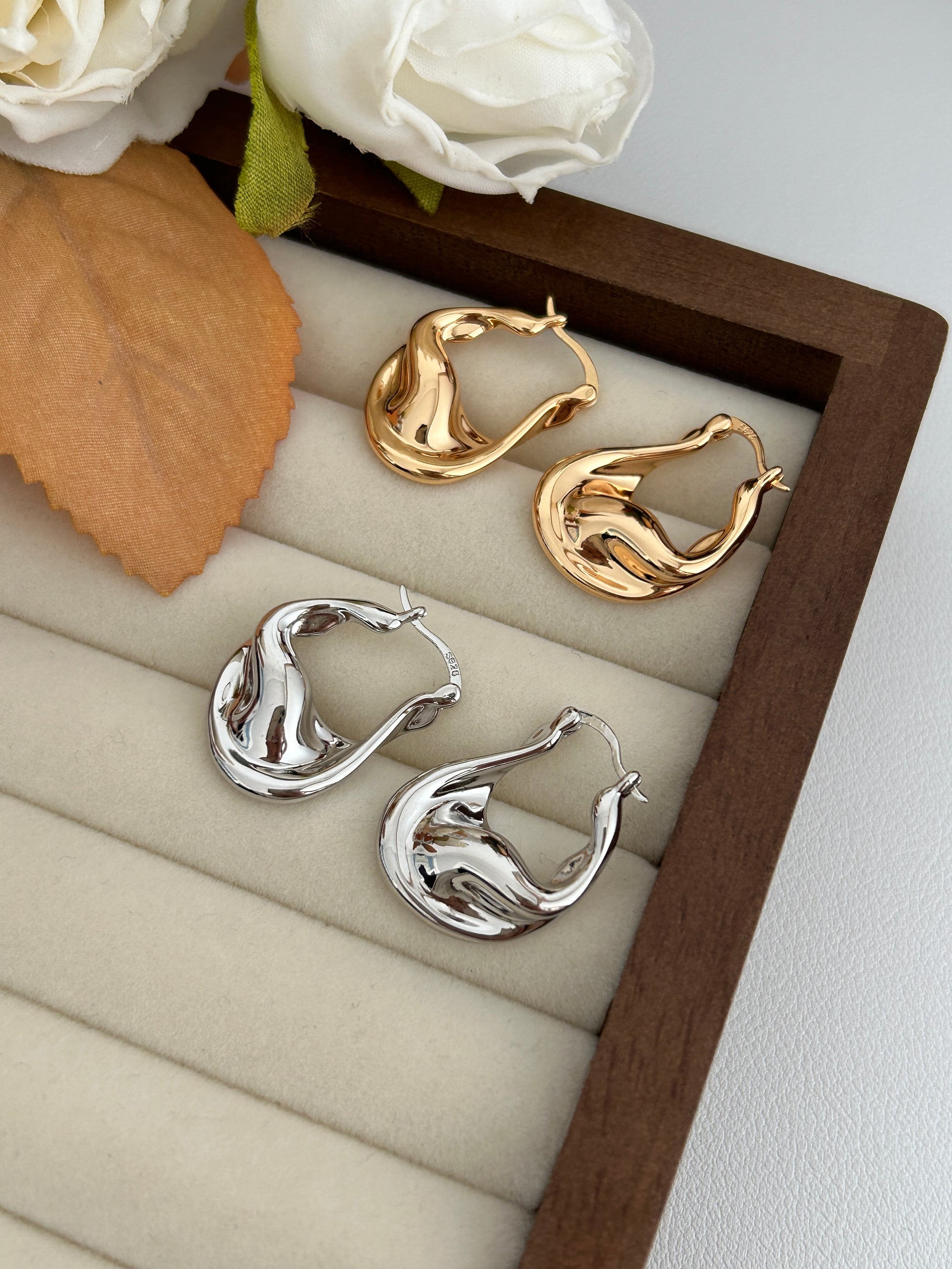 Fluid hoop earrings in vintage gold and sterling silver, wavy sculpted profile