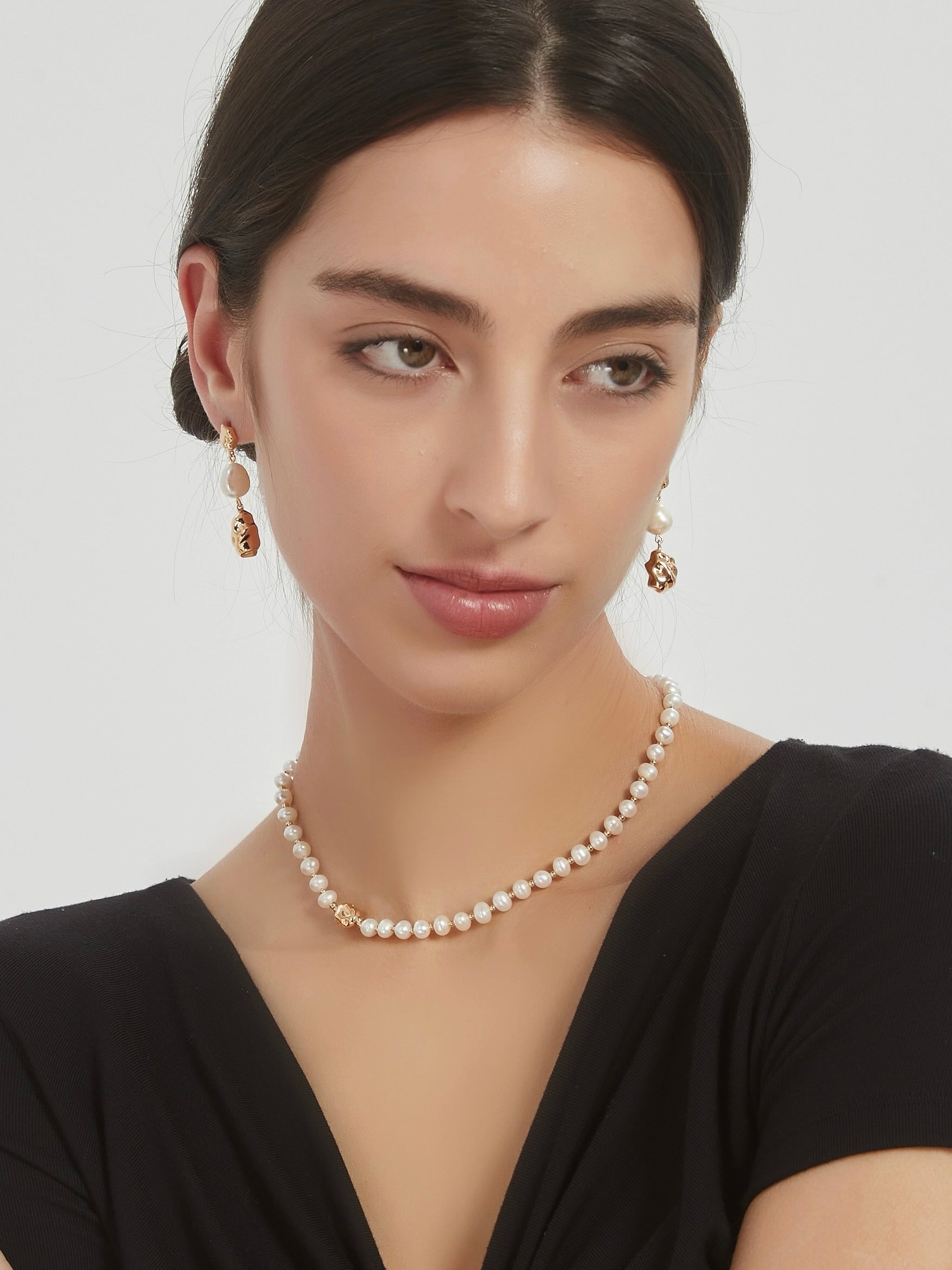 Natural pearl necklace worn by model, three strands of small pearls with clasp
