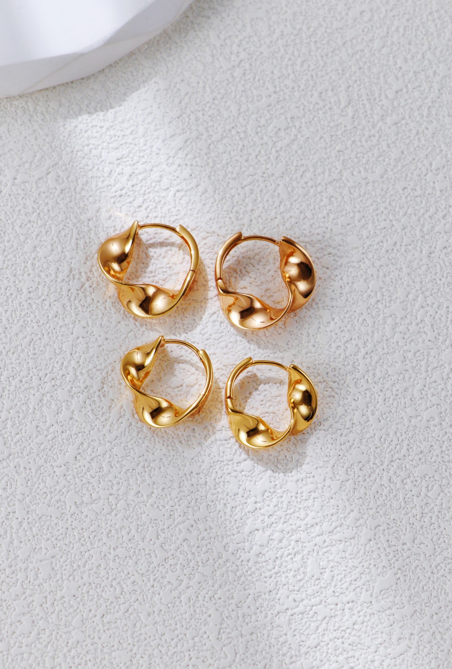 Set of twisted gold hoop earrings, circular twist with small bead-like details
